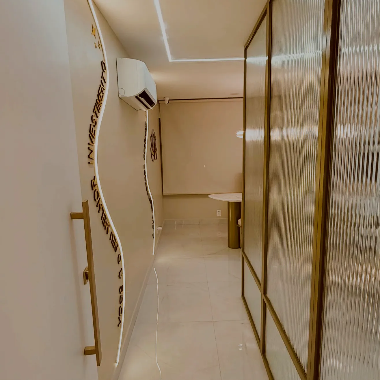 Corredor com linha de luz sinuosa e divisórias de vidro canelado